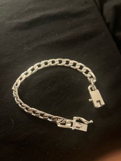 Polished silver-toned bracelet has a curb link design. This piece is made of a metallic material with a bright finish. It has a secure box clasp with 