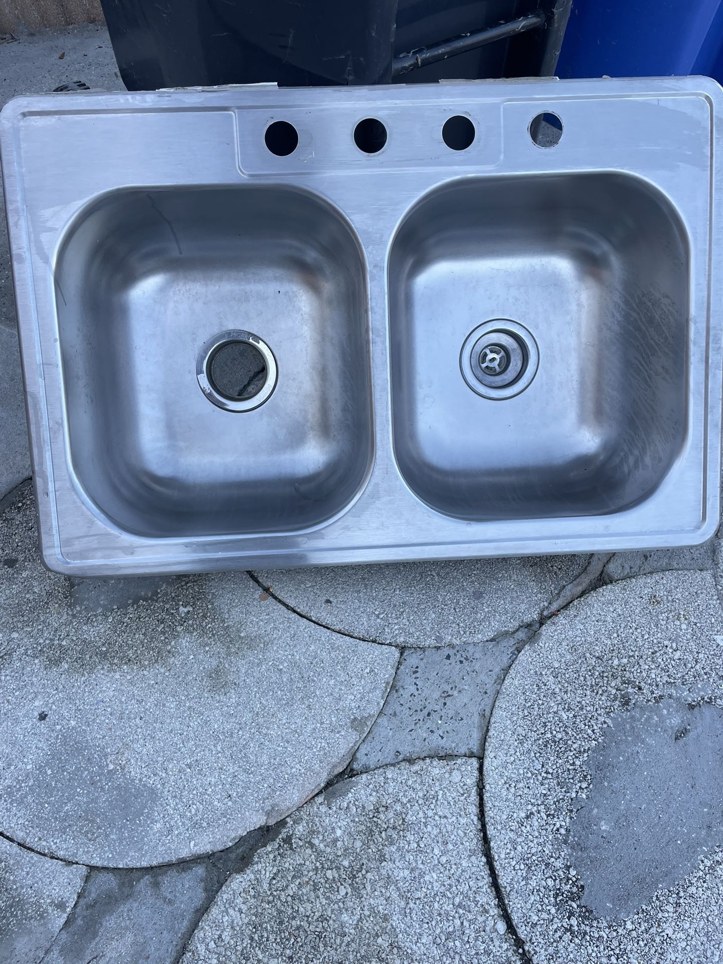 I 2-hole sink in good condition measures 33 inches long, 22 inches wide, 8 inches deep, each hole measures 14 inches