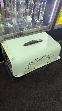 pale aqua Petmate Pet Porter kennel features a black plastic handle and a ventilation grid on the side.