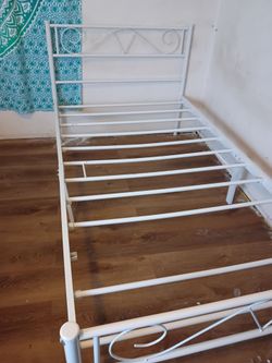 two white iron twin bed frames
