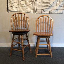 Two wooden swivel bar stools