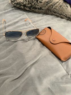 Ray-Ban Aviator sunglasses with a gold-tone metal frame and blue-gray gradient lenses.