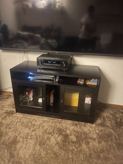 Dark Wood Entertainment Center With Two Cabinets With Glass Doors.