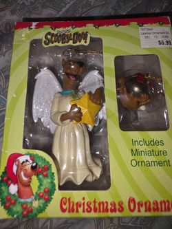 This vintage 1999 Scooby-Doo angel Christmas ornament features Scooby wearing a white robe and holding a gold star.