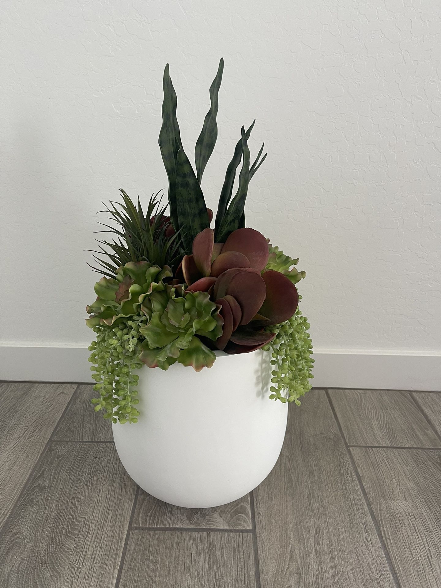 Faux plant in white pot