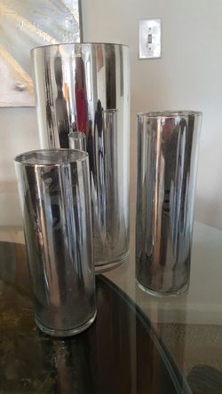 Este hermoso trío de vase para flores y velas decorado con una mezcla de pintura plateado haciéndola lucir como espejo son preciosas