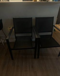 pair of modern black metal patio armchairs
