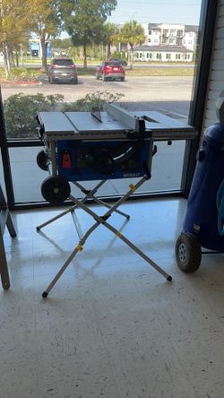 Kobalt 10-inch 15-Amp Corded Portable Jobsite Table Saw mounted on a foldable rolling stand