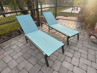 A set of teal foldable lawn chairs