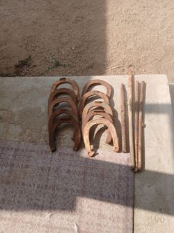 Old rusty steel horse shoes & poles
