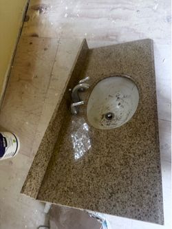 Granite counter top bathroom sink with metal attachments.