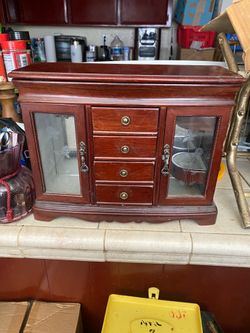 vintage wooden jewelry box features two etched glass doors and four central drawers.