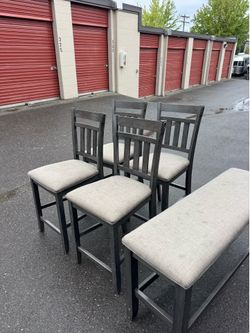 Four wooden high chairs and a bench