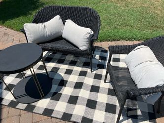 Outdoor furniture, loveseat, and chair with rug and table and cushion