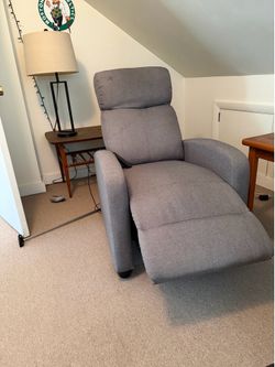 Gray massaging chair with remote.