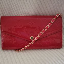 Louis Vuitton Sarah Wallet in Monogram Vernis patent leather, specifically in a color like Cerise or Cherry.