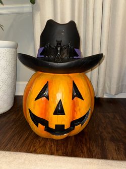 Halloween jack-o’-lantern decoration wearing a black witch hat