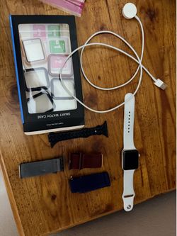 2 Apple Watches series 1 with multiple accessories
