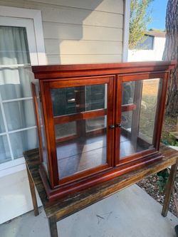 Cherry Wood Glass Display Cabinet with Mirrored Back 📏 Dimensions: Approx. 39”W × 30”H × 12.5”D Beautiful cherry-finish display cabinet featuring d