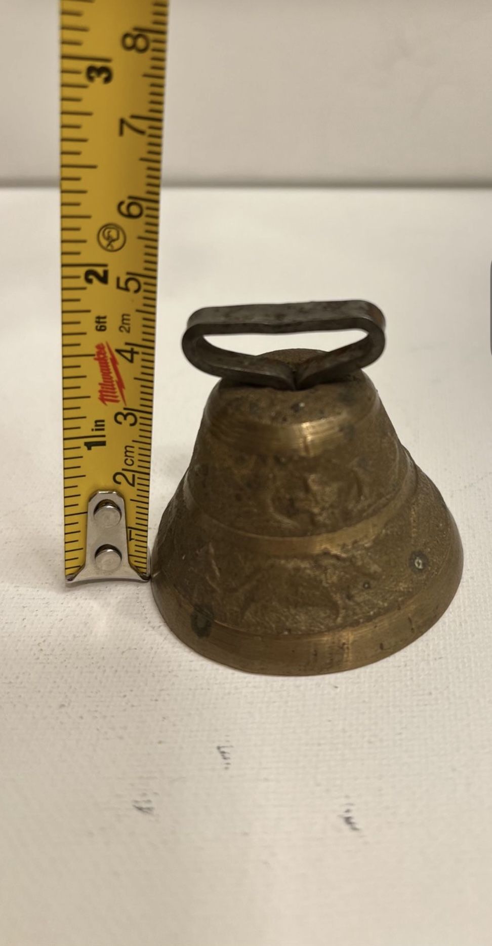 Antique bronze bell with a house, a man and a cow