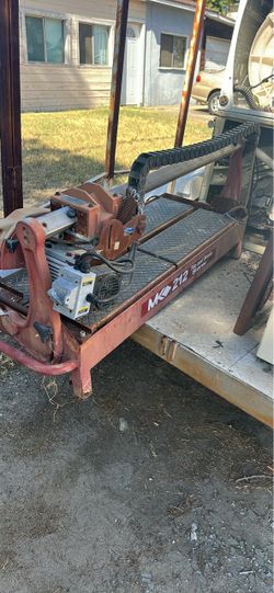 Heavy-duty MK Diamond MK-212 tile and stone saw is constructed of red painted steel. It has a sliding rail system with a black plastic cable carrier a