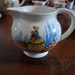 Vintage ceramic creamer jug featuring a transferware design of a "Crinoline Lady" in a garden.
