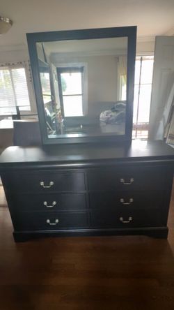 Wood dresser with mounted mirror.