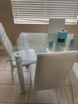 Glass dinette set with 4 white chairs