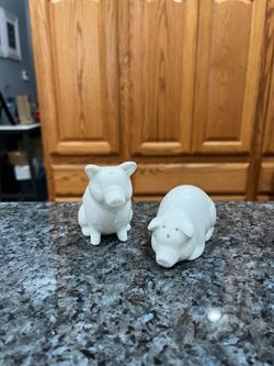 Ceramic White Pig Pair of Salt and Pepper Shakers.  One pig is sitting down the other pig is laying down.  The Tallest is 3 inches tall.  Preowned nev