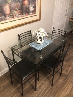 Like new Glass dining table set with 4 black leather chairs