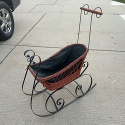 Wicker & wrought iron sleigh used as a decorative holiday prop or for displaying dolls