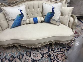 Ornate armchair with heavily carved gold-leaf frame, tufted cream upholstered seat, and burgundy floral tapestry back cushion. Features cabriole legs 