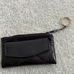 Small black textured coin purse with exterior flap, snap pocket and zip of closure with key ring