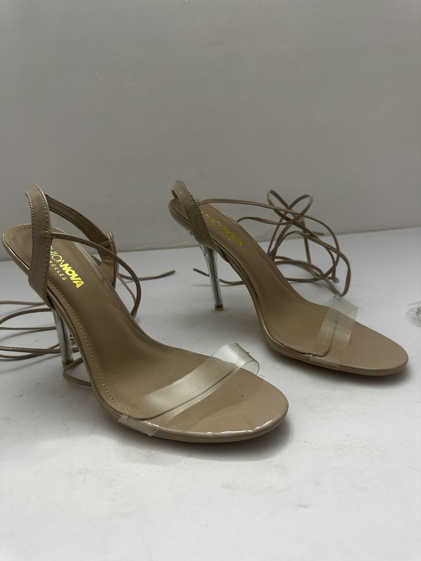 Fashion Nova Tay heeled sandals with clear straps and lucite heels, in a nude or beige color. Size medium