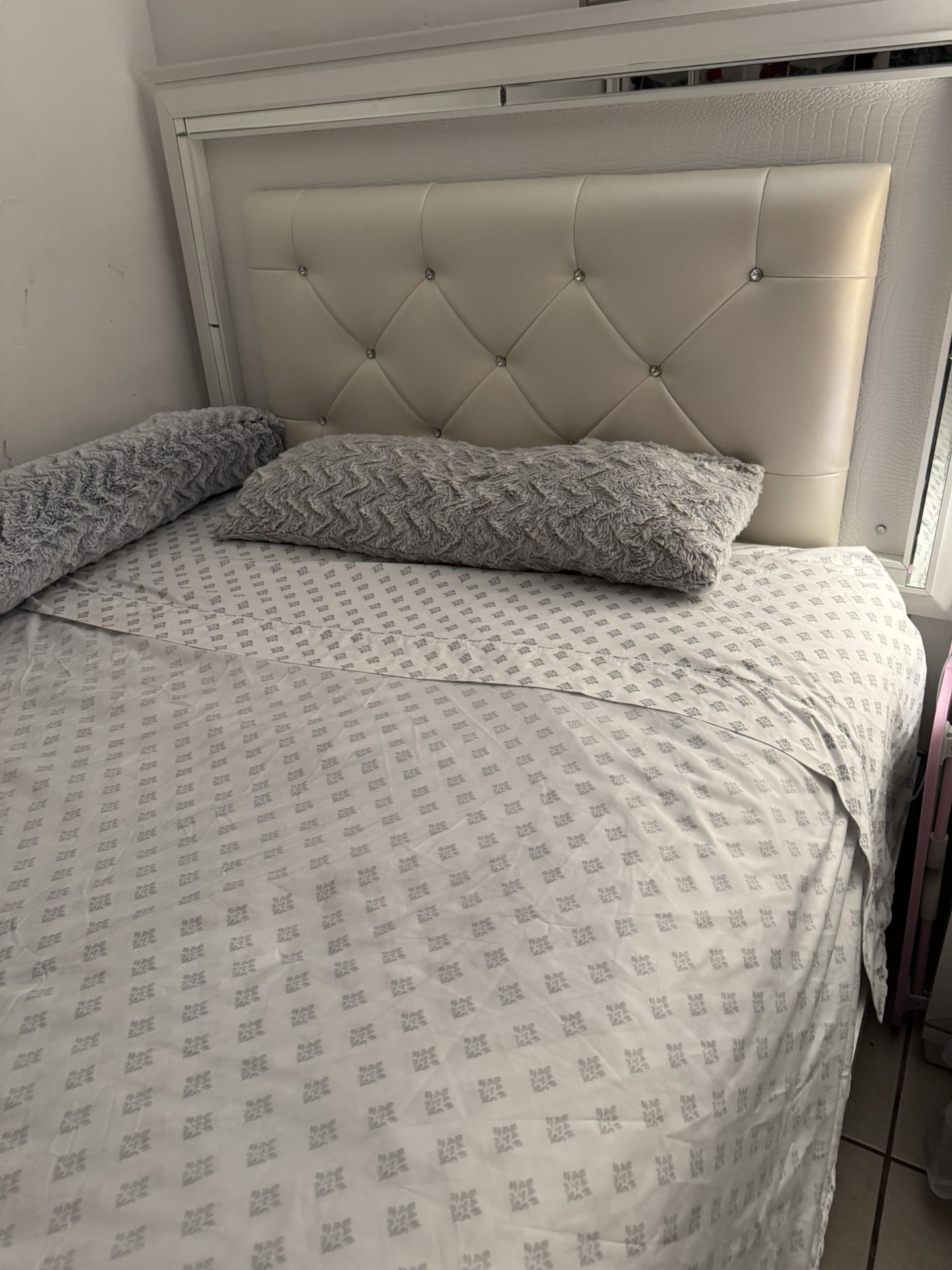 Una Cama Queen En Muy Buenas Condiciones Blanca Y Con Su Luz Al Borde De La Cabecera