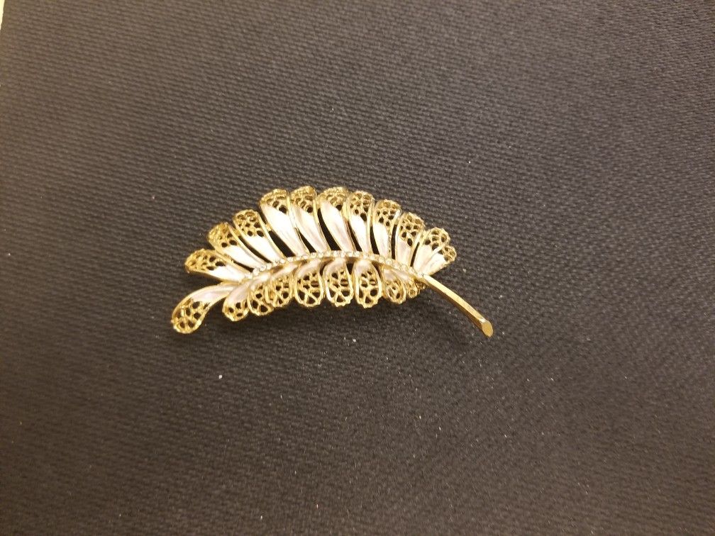 BSK lacy leaf brooch with pearlized enamel and a rhinestone stem in gold finish.