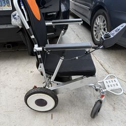 Lightweight folding electric wheelchair in working condition.  • Powers on and drives properly • Joystick control • Compact travel/folding design • Ea