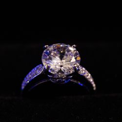 3 carat Moissanite in a 14 karat gold plated silver ring. Save some money for your proposal!