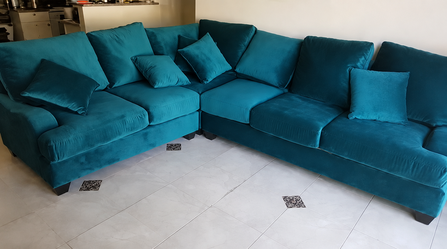 Teal velvet sectional sofa with throw pillows