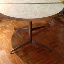 1970's gold colored formica round table with silver legs.