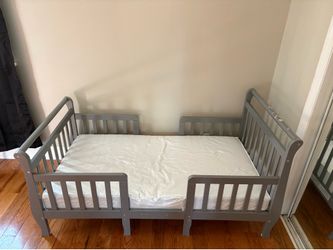 Gray toddler bed with mattress