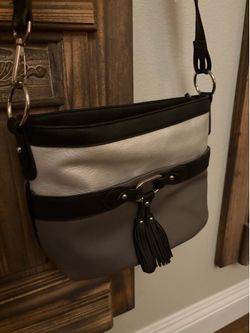 Rosetti tri-tone crossbody bag in black, white, and grey with tassel details.