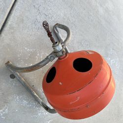 A hand-cranked (or electrically powered) drain snake.