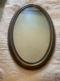 Oval mirror with bronze frame.