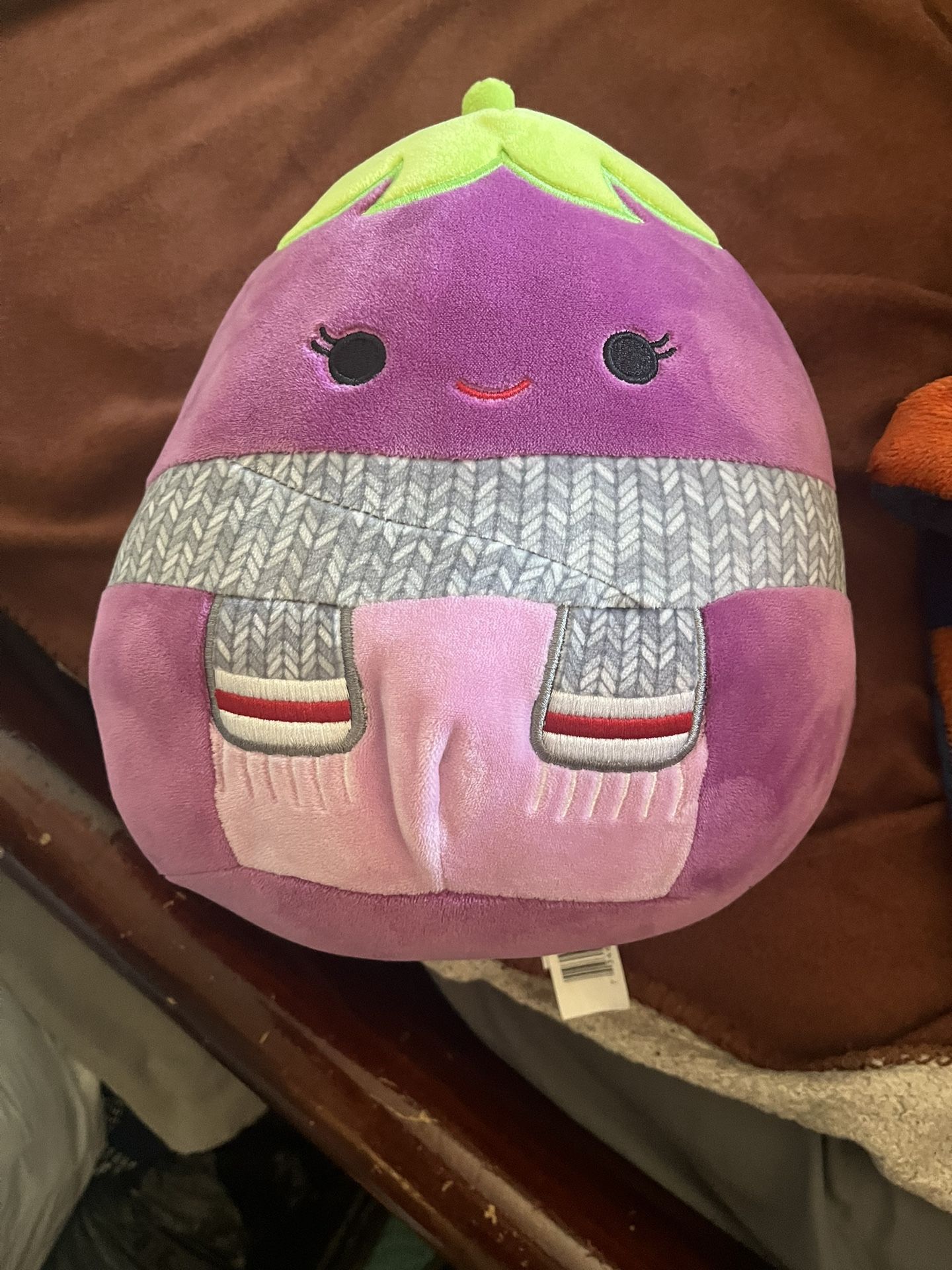 Squishmallows Glena the Eggplant plush toy with a scarf