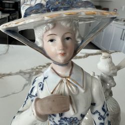 Vintage statue woman with hat and umbrella
