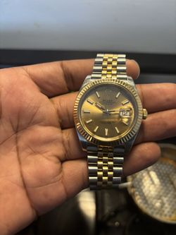 The watch in the image is a Rolex Datejust 41 in Oystersteel and yellow gold (Reference number 126333) featuring a champagne-colored dial and a Jubile
