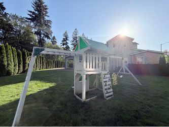 Costco playstructure with 3 swings , monkey bars , slide , under PlayStation and bench