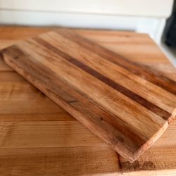 Handmade 16” rectangular striped wooden cutting board crafted from a mix of hardwoods such asmaple, walnut, and cherry