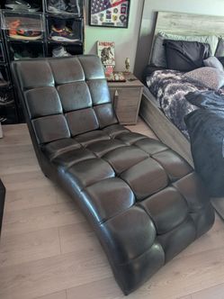 curved, tufted faux leather chaise lounge chair with a waffle-grid pattern